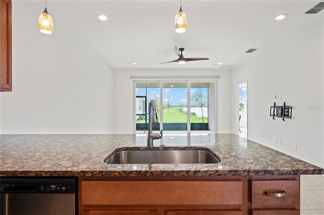 kitchen with dark stone counters, sink, decorative light fixtures, and dishwasher