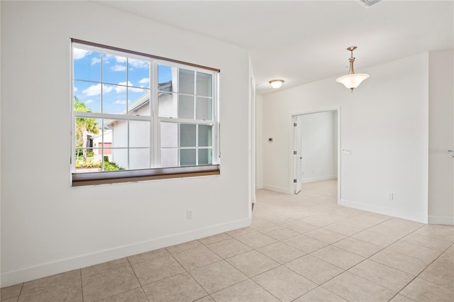 unfurnished room with light tile patterned floors and baseboards