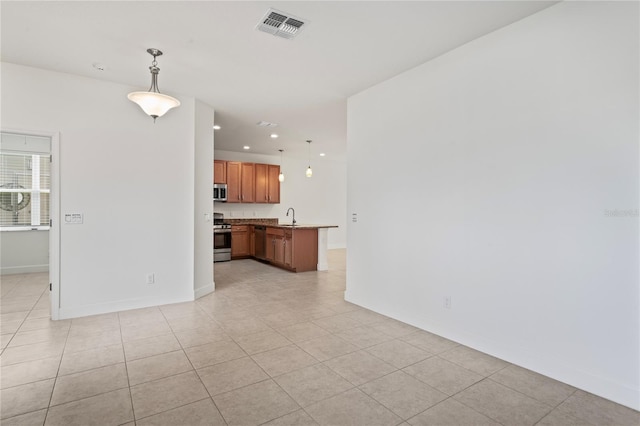 unfurnished living room with recessed lighting, baseboards, visible vents, a sink, and light tile patterned flooring