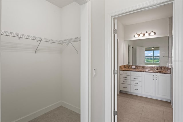 walk in closet featuring a sink and light tile patterned floors