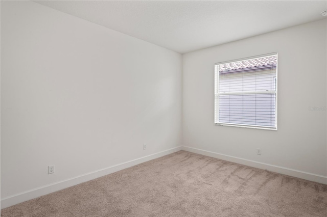 empty room with light carpet and baseboards
