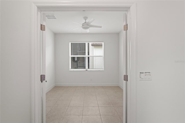 empty room with light tile patterned floors and ceiling fan