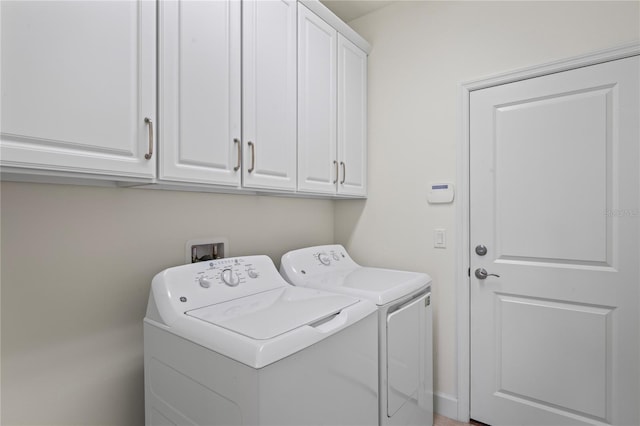 clothes washing area with cabinet space and independent washer and dryer
