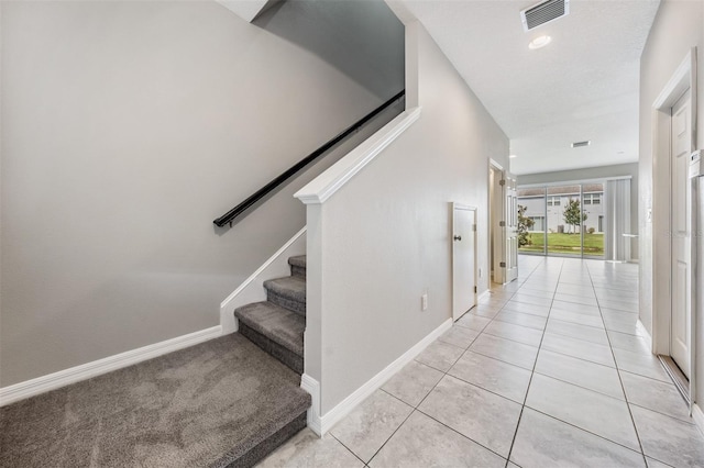 staircase featuring tile patterned floors