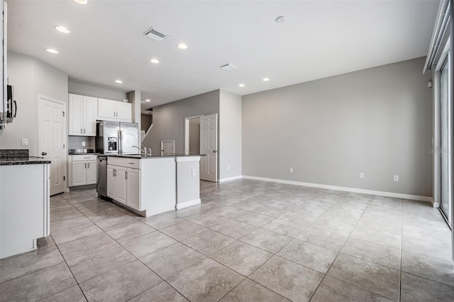 kitchen with an island with sink, light tile patterned floors, white cabinets, and stainless steel fridge with ice dispenser