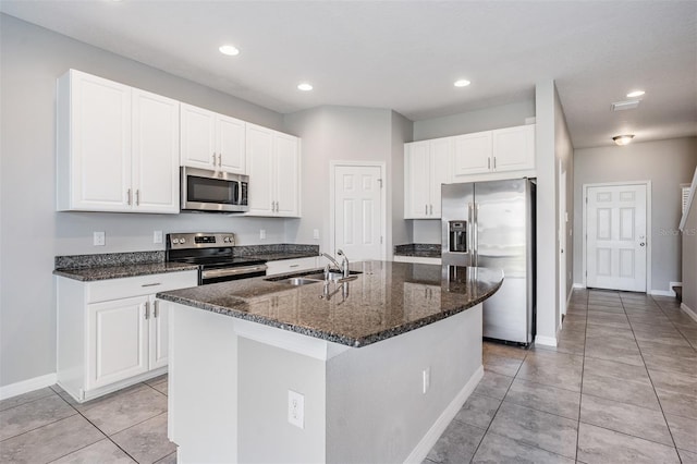 kitchen with stainless steel appliances, a kitchen island with sink, sink, and white cabinets