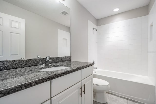 full bathroom featuring tiled shower / bath, vanity, toilet, and tile patterned flooring