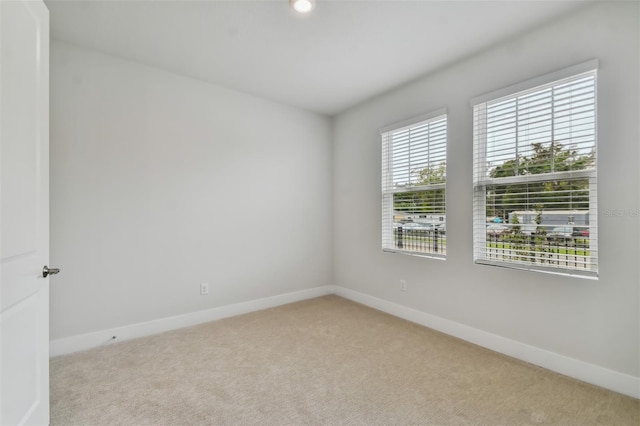 carpeted spare room featuring a healthy amount of sunlight