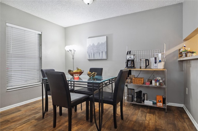 dining room featuring dark wood-type flooring and a textured ceiling