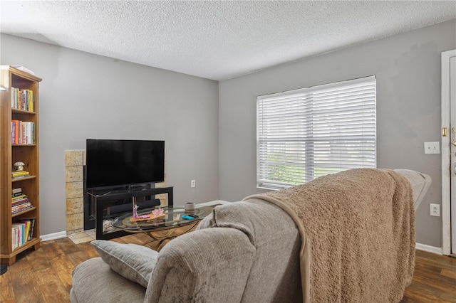 living room with dark hardwood / wood-style flooring and a textured ceiling