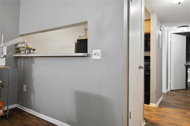 corridor featuring dark hardwood / wood-style flooring and a textured ceiling