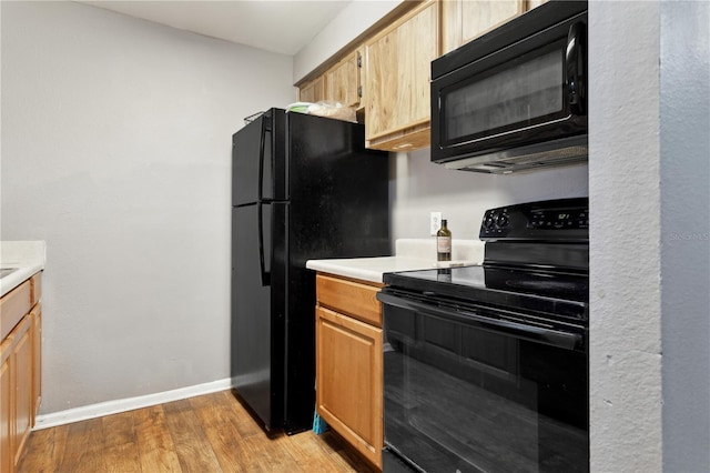 kitchen featuring light brown cabinets, black appliances, and light wood-type flooring