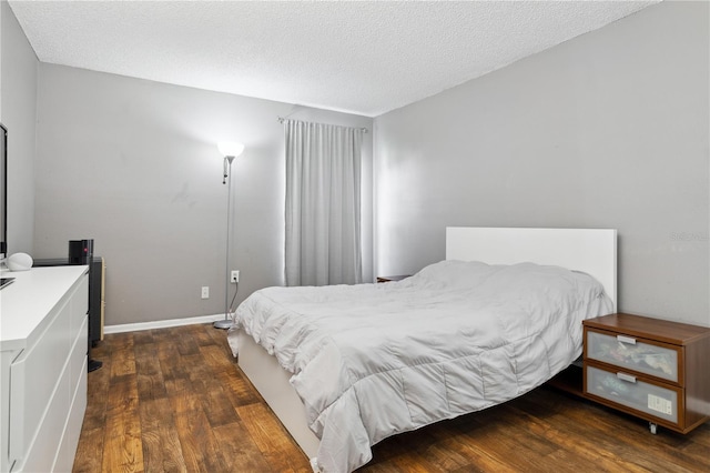 bedroom featuring a textured ceiling and dark hardwood / wood-style floors