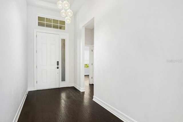 foyer with dark hardwood / wood-style flooring and an inviting chandelier