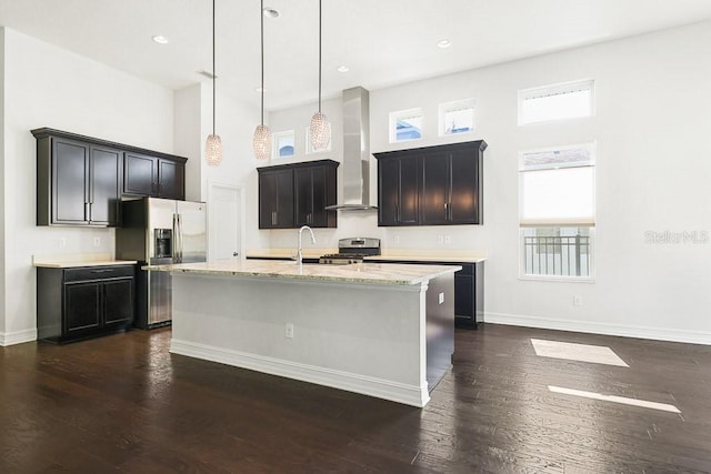 kitchen with appliances with stainless steel finishes, dark wood-type flooring, an island with sink, and plenty of natural light