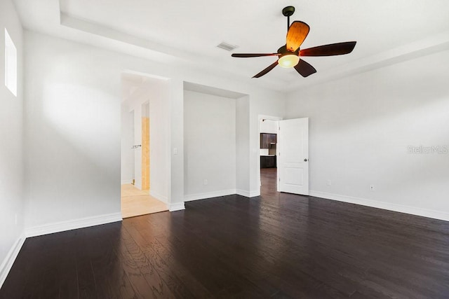 empty room with dark hardwood / wood-style floors and ceiling fan