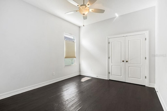 unfurnished bedroom with dark wood-type flooring, a closet, and ceiling fan