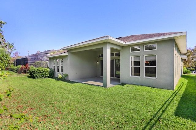 rear view of property featuring a patio, a lanai, a yard, and ceiling fan