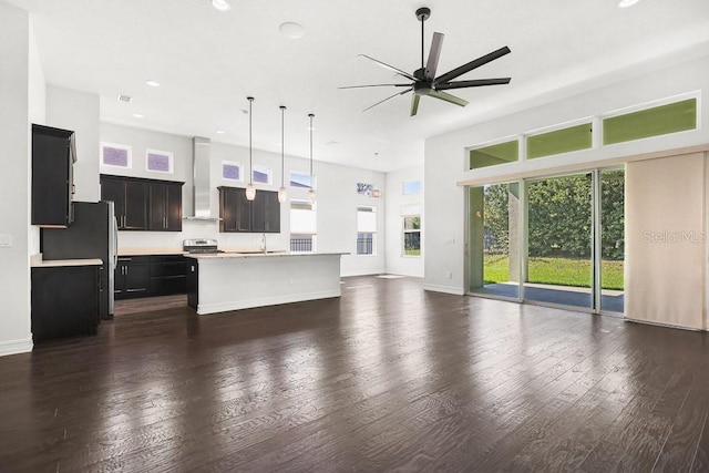 unfurnished living room featuring ceiling fan, sink, and dark hardwood / wood-style flooring