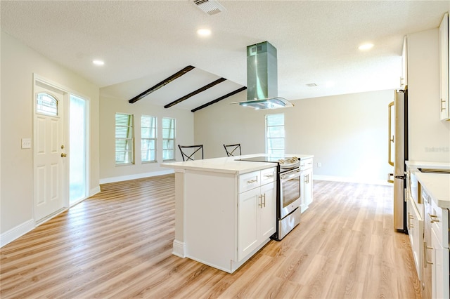 kitchen featuring white cabinets, lofted ceiling with beams, light hardwood / wood-style flooring, island range hood, and stainless steel appliances