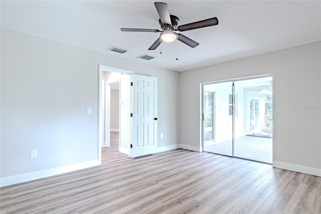 unfurnished room with a textured ceiling, light hardwood / wood-style floors, and ceiling fan