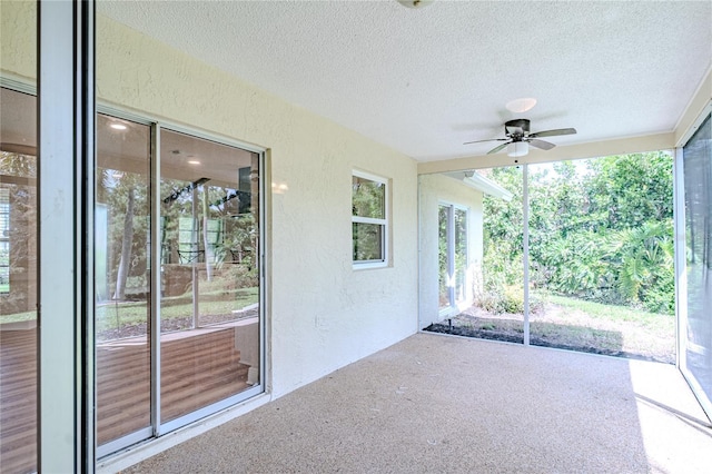 unfurnished sunroom with ceiling fan