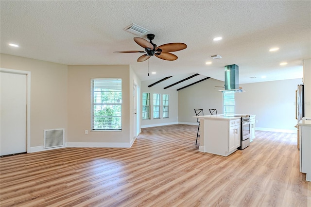 kitchen featuring island exhaust hood, a center island, stainless steel appliances, and white cabinetry