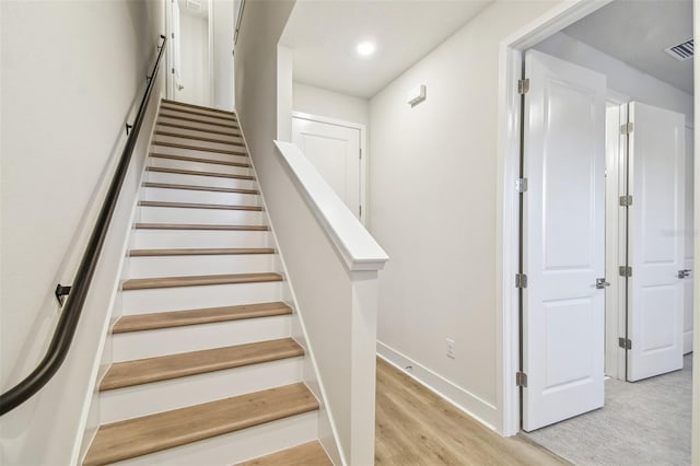 stairs featuring hardwood / wood-style floors