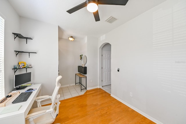 office with light wood-type flooring and ceiling fan