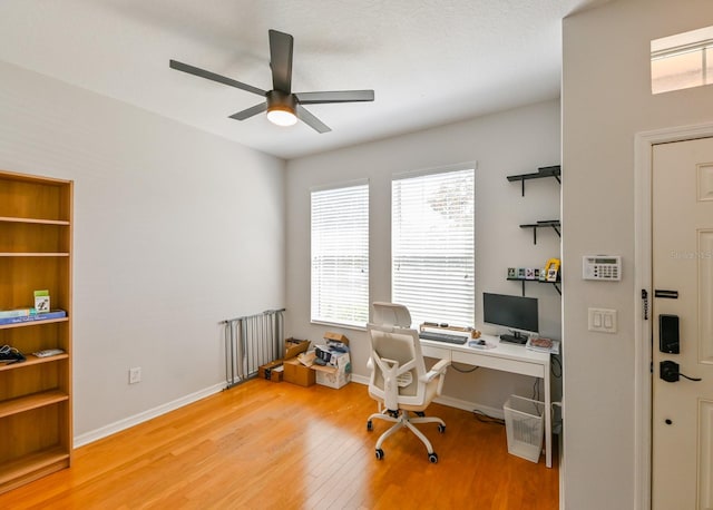 home office with hardwood / wood-style floors and ceiling fan