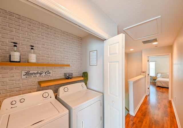 washroom featuring washing machine and dryer and dark wood-type flooring