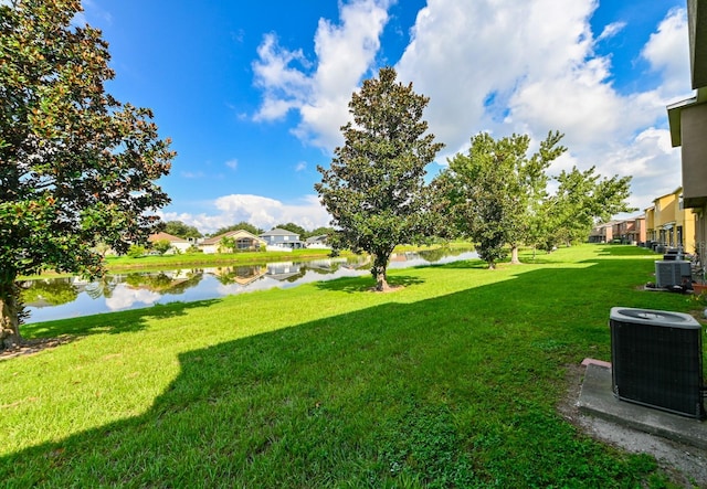 view of yard with central AC and a water view