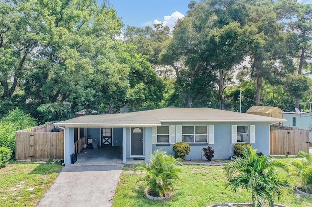 1611 Stevenson Dr, Clearwater, FL 33755 - ranch-style house with asphalt driveway, an attached carport, stucco siding, and a gate