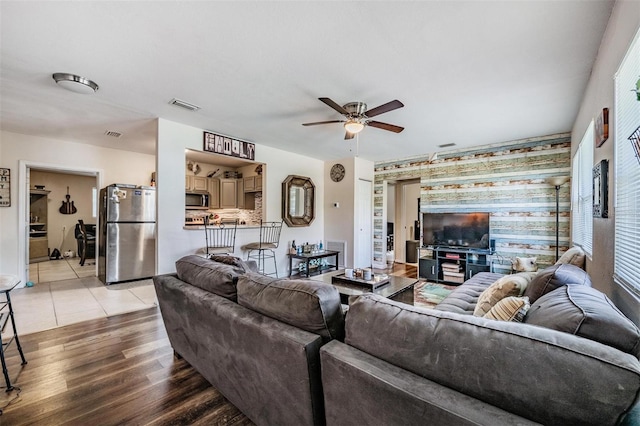 1611 Stevenson Dr, Clearwater, FL 33755 - living room featuring an accent wall, ceiling fan, and light wood-type flooring