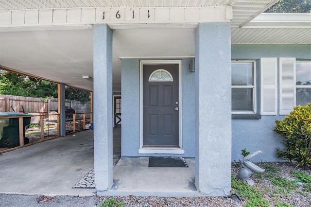 1611 Stevenson Dr, Clearwater, FL 33755 - doorway to property featuring stucco siding and a carport