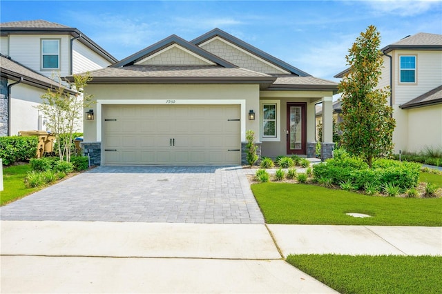 view of front facade with a front lawn, decorative driveway, an attached garage, and stucco siding