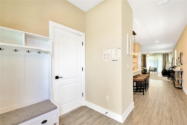 mudroom featuring light wood-style flooring, visible vents, and baseboards