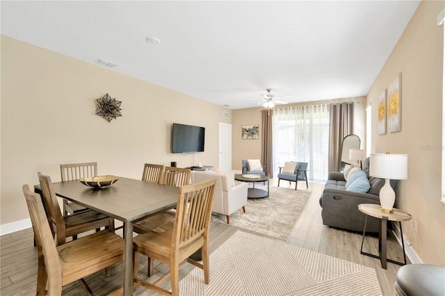 dining area with ceiling fan and light hardwood / wood-style floors