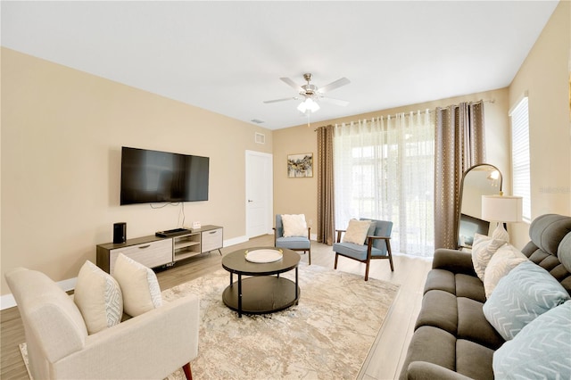 living room with ceiling fan and light wood-type flooring