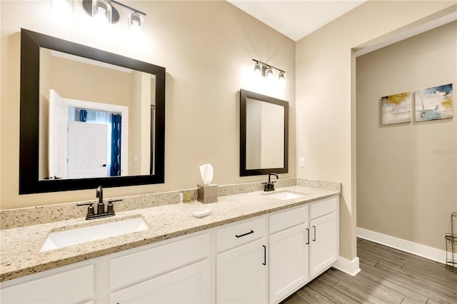 bathroom featuring dual vanity and wood-type flooring