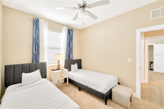 bedroom with baseboards, visible vents, a ceiling fan, and light colored carpet