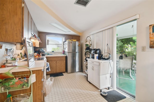 kitchen featuring white cabinets, stainless steel refrigerator, ventilation hood, and light tile patterned flooring