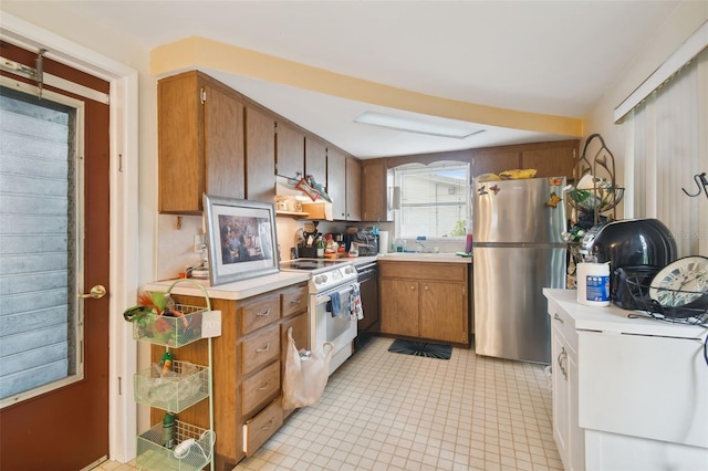 kitchen featuring ventilation hood, white electric range oven, light tile patterned floors, black dishwasher, and stainless steel fridge