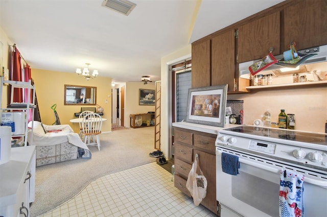 kitchen with a notable chandelier, electric stove, and light carpet