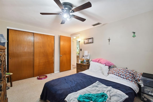 carpeted bedroom featuring ceiling fan and a closet