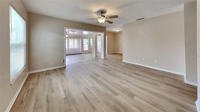 unfurnished room with ceiling fan, a textured ceiling, and light hardwood / wood-style flooring