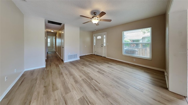 entryway with ceiling fan, light wood-type flooring, and a textured ceiling