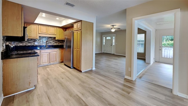 kitchen featuring sink, light wood-type flooring, decorative backsplash, ceiling fan, and stainless steel appliances