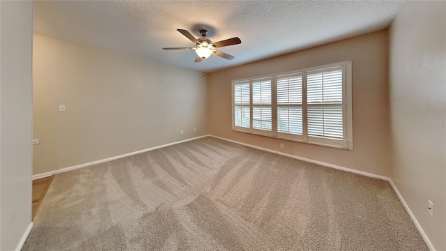 spare room with ceiling fan, a textured ceiling, and light carpet