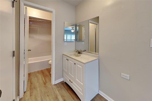 full bathroom featuring hardwood / wood-style flooring, vanity, shower / bathing tub combination, and toilet